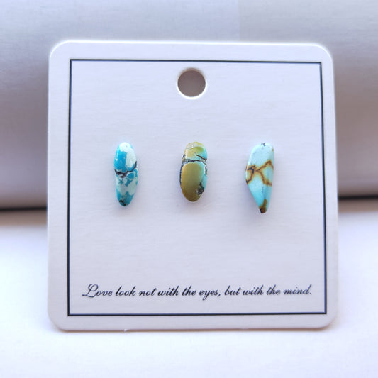 Turquoise stone earrings on a display card with a quote.